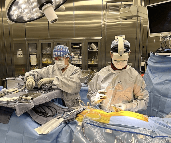 A surgeon uses an AR headset to perform spine surgery