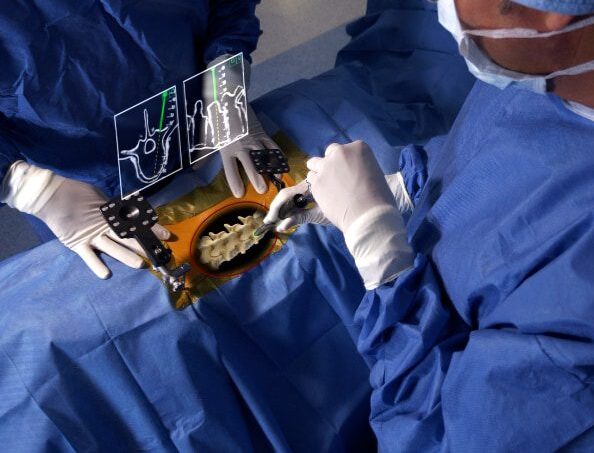 two surgeons operate on spine using augmented reality